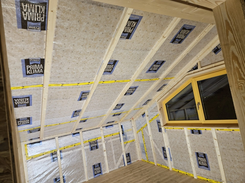 Ausgebaute Dachgeschossdecke und -wände mit Dämmung und Holzlatten im Trockenbau
