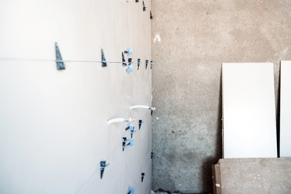 Wand mit Fliesenabstandhaltern und Gipskartonplatten, Vorbereitung für Fliesenlegerarbeiten
