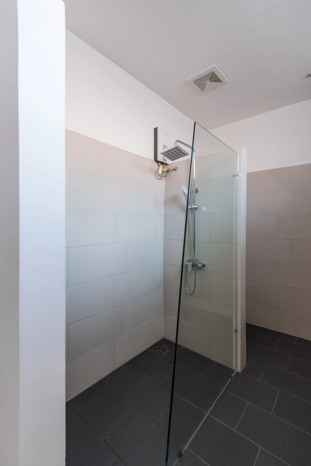Walk-in-Dusche mit Glasabtrennung, hellen Wandfliesen und anthrazitfarbenen Bodenfliesen - Dusche einbauen