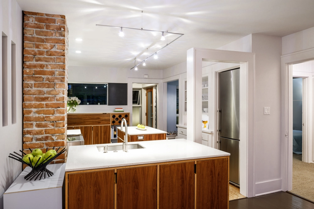 Renovierte moderne Küche mit Kücheninsel, weißer Arbeitsplatte, Holzschränken und Edelstahlgeräten Küchenmontage